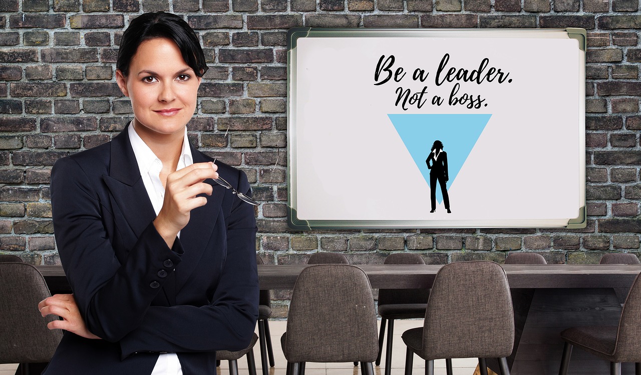 Be a leader not a boss - kvinna i kostym som håller i glasögon